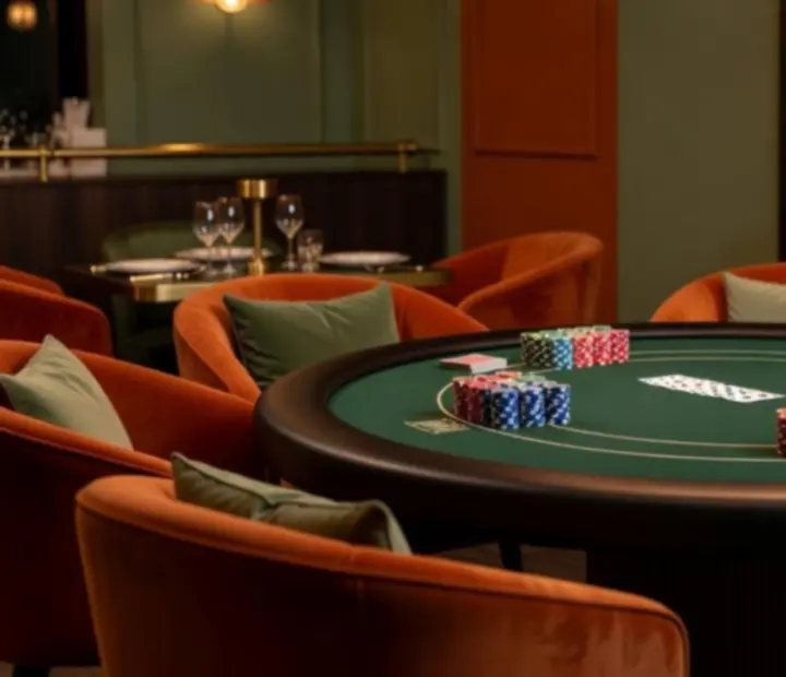 Stół pokerowy w przyciemnionej przestrzeni card lounge